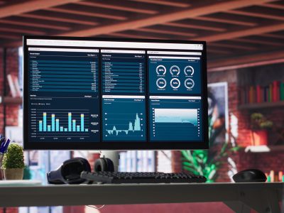Desktop PC on the wooden desk showcases infographics and client reach data Desktop PC on the wooden desk showcases infographics and client reach data for professional use, analytics on display. Stylish, organized workspace in a bright luxurious loft home.